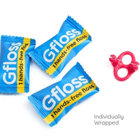 Individually wrapped Gfloss flossers in candy-style wrappers with a pink flosser unit